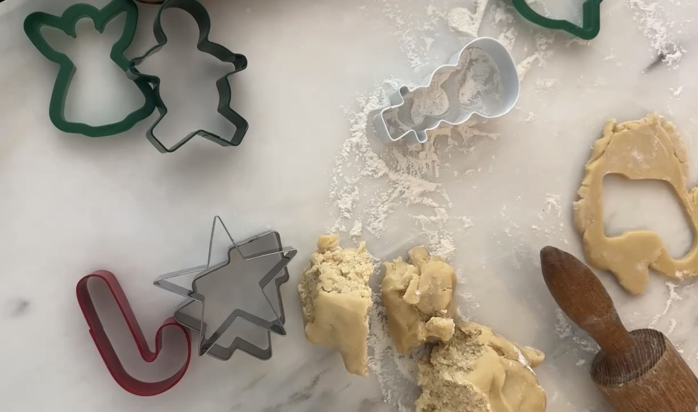 Rolling out sugar cookie dough with Christmas cookie cutters